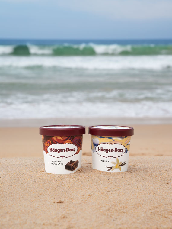 Two pints of Häagen-Dazs ice cream on a beach